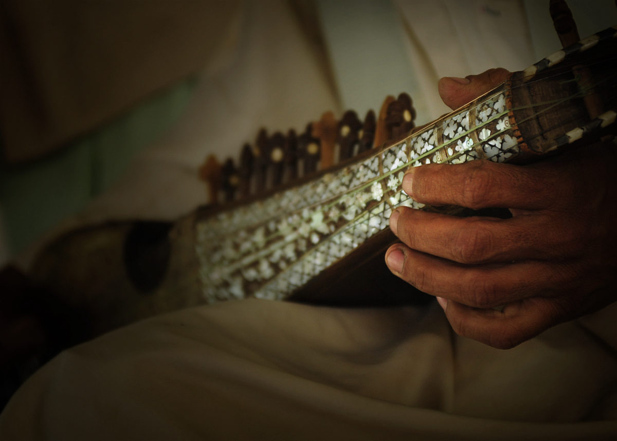 Hand spielt die Rubab, ein traditionelles afghanisches Saiteninstrument